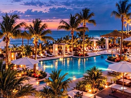 Palm-lined pool and beach at dusk, the resort photograph from the campaign flyer.